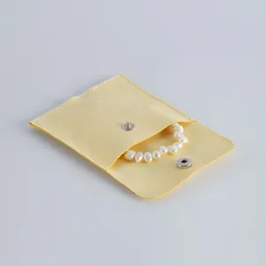 Gelber Wildleder Schmuckbeutel mit Druckknopf und Perlenarmband Detailaufnahme fur Aufbewahrung