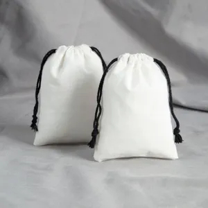 Detailansicht von weissen Baumwolltaschen mit schwarzen Kordeln fuer Geschenke und Schmuck.