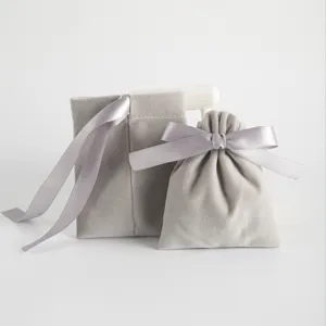 Detailaufnahme des grauen Samt Schmuckbeutels mit eleganter silberner Schleife für Geschenke.