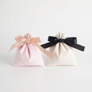 Detailansicht eleganter Samt-Kordelzugbeutel mit Schleifen in Rosa und Beige für Schmuckgeschenke.