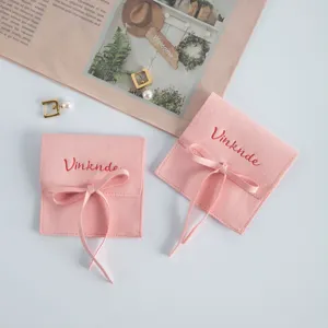 Dettaglio sacchetto portagioie in camoscio rosa, bustina in morbido velluto con elegante fiocco.
