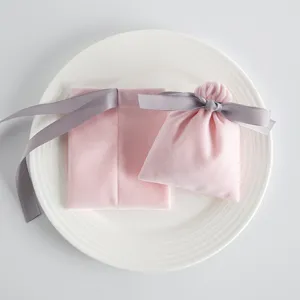 Nahaufnahme des rosa Samt Schmuckbeutels mit elegantem grauen Schleifenband Detail.