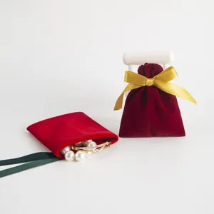 Roter Samt Kordelzugbeutel fuer Schmuck und Geschenke mit goldener Schleife Detail.