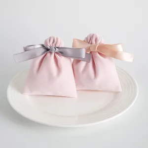 Rosa Samtbeutel mit Kordelzug und Schleife, ideal für Geschenk- und Schmuckverpackungsdetails.