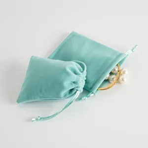 Close-up detailopname van zacht turquoise fluwelen sieraden opbergzakje met fijn koord.