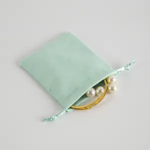 Sacchetto con coulisse in velluto verde chiaro per confezione regalo gioielli con bracciale d'oro.