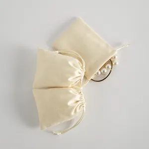 Beige Samt Kordelzug Beutel Detailansicht, weiche Schmuck Geschenk Verpackung Naheaufnahme.