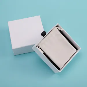 Weisse Schmuckgeschenkbox mit beige Samtbeutel Detailaufnahme, sauberer Hintergrund.