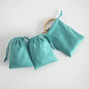 Turquoise velvet jewelry pouch detail showing soft texture and delicate drawstring closure.
