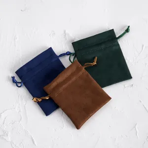 Detailaufnahme von weichen Wildleder Kordelzugbeuteln in den Farben Blau, Braun und Grün.