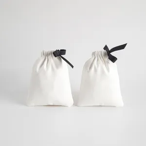 Weißer Samt Kordelzug Schmuckbeutel Detail, weiche Stofftasche mit eleganter schwarzer Schleife.