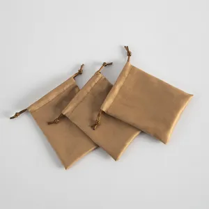 Nahaufnahme von drei weichen braunen Wildleder Kordelzug Schmuckbeuteln mit feiner Textur.