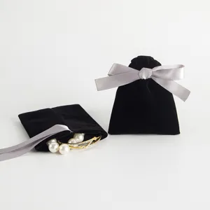 Schwarzer Samt Schmuckaufbewahrungsbeutel mit grauer Schleife, ideal als Geschenkverpackung.
