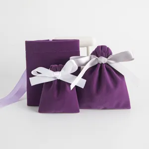 Detailed showcase of purple velvet drawstring bags with white bows for jewelry gift packing.