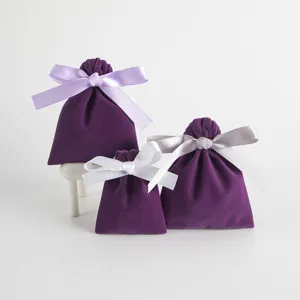Detail view of purple velvet drawstring pouches with ribbons, perfect for jewelry gift storage.