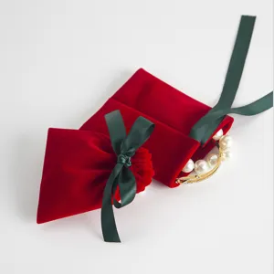 Roter Samt Schmuckbeutel mit gruenem Band, perfekt fuer Accessoires und edle Geschenkverpackungen.