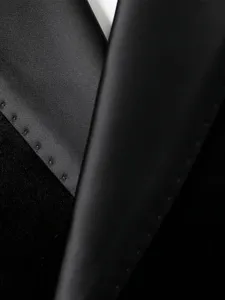 Detalle de chaqueta de traje negra para hombre, textura de terciopelo y satén, elegante.