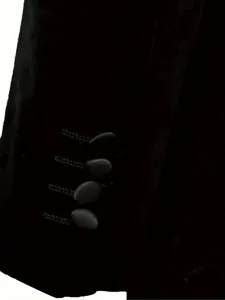 Primer plano detalle de puño de chaqueta de traje de terciopelo negro para hombres.