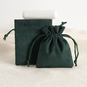 Dark green velvet drawstring pouch detail view, soft suede jewelry storage gift packaging.