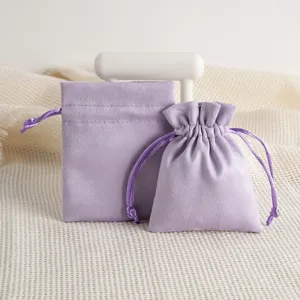 Detailed close-up of lavender suede velvet jewelry drawstring pouches with smooth fabric texture.