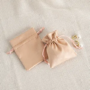 Detailed view of soft beige velvet drawstring pouches for jewelry storage and gift packaging.