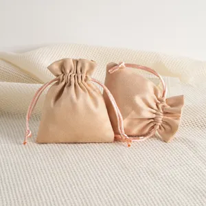 Detailed view of champagne color velvet jewelry drawstring pouch, soft fabric and elegant texture.
