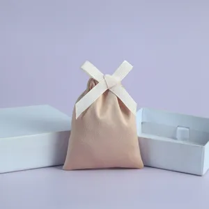 Eleganter Wildleder-Schmuckbeutel mit weißer Schleife für Geschenke und Aufbewahrung.