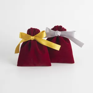 Rote Samttaschen Detail mit goldenen und silbernen Schleifen für Schmuck und Geschenke verpacken.