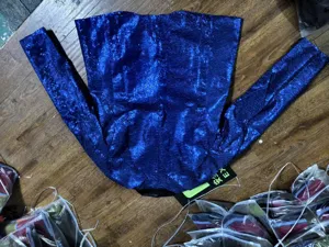 Vista dettagliata del blazer in paillettes blu scuro con trama di tessuto brillante.