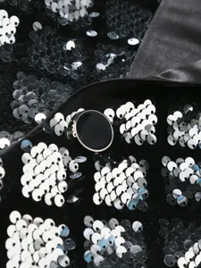Men's sequin suit detail shot showing sparkling diamond patterns, satin lapel, and sleek button.