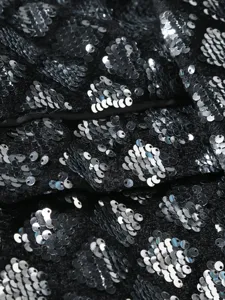 Close-up detail of luxury men sequin suit fabric, sparkling silver sequins on black velvet.