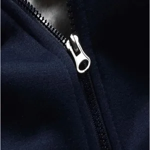 Detailed shot of dark blue fleece hoodie metal zipper, premium winter outerwear texture.