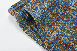 Dettaglio di pantaloni casual da uomo con stampa floreale in cotone e lino, tasca e vita elastica.