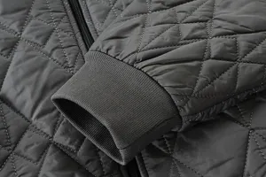 Men's winter padded jacket sleeve detail, dark grey quilted fabric with comfortable ribbed cuff