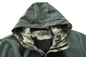 Men's hooded jacket detail close-up showing green fabric, camo hood lining and zipper.