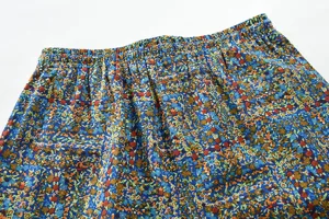 Dettaglio pantaloni casual uomo stampa floreale, comodo elastico in vita, tessuto cotone lino morbido.