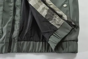 Men's green tactical jacket detail view, featuring contrast camo lining and zippers.
