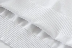 Close up detail of white men knitted sweater rib cuffing showing premium texture quality.