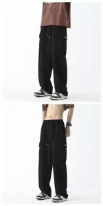 Detail view of men's loose wide-leg cargo pants in black, featuring side utility pockets.