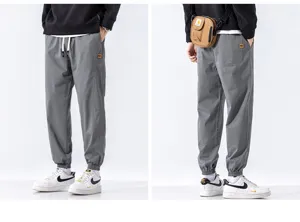 Mens grey casual cargo pants loose fit streetwear cuffed jogger trousers with drawstring waist.