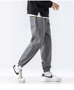 Men's casual cargo joggers detail shot, loose fit trousers with elastic cuffs for autumn.