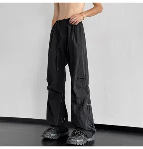 Detalles del pantalón paraguas streetwear negro con cordones ajustables y ojales metálicos.