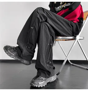 Pantalón paracaídas negro unisex de estilo streetwear con prácticos cordones ajustables.