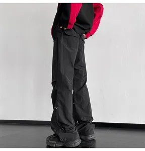Vista detallada de pantalones cargo paracaídas negros, corte holgado y estilo urbano.