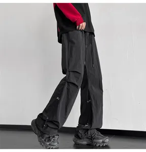 Pantalón parachute negro holgado de estilo urbano con amplios bolsillos y cordones.