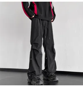 Pantalones paracaídas negros holgados para hombre y mujer, estilo urbano con cordón ajustable.
