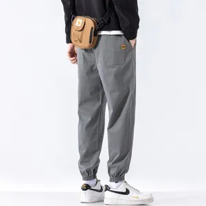 Men's casual cargo joggers in grey, loose fit harem pants with cuffed hems for autumn styling.