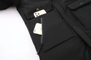 Men black winter parka jacket detail close up showing multi pockets zipper and functional design.