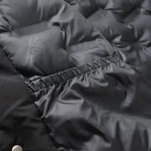Detailed shot of black quilted padded jacket with elastic cuffs and cozy winter fabric.