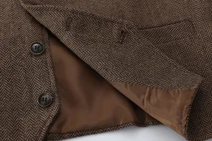 Close-up view of brown herringbone waistcoat detail showing buttons and smooth inner lining.